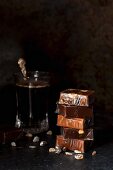 A stack of cellophane-wrapped caramel bonbons, next to a glass of coffee