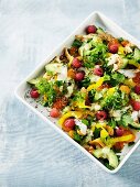 A colourful salad with avocado, peppers, fish and raspberries