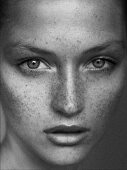 A close-up portrait of a young woman with lots of freckles (black-and-white shot)