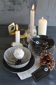 Dekorative Porzellanschalen mit silberner Eule und handbemalte Geschenketiketten vor brennenden Kerzen