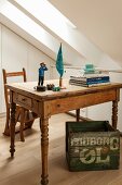 Vintage Holztisch mit Bücherstapel und Comicfigur, darunter bedruckte Holzkiste in Dachzimmer