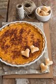 A rustic pumpkin tart decorated with pastry hearts