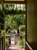 View through open front door and open front gate to street