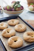 Baked choux pastry rings on a baking tray