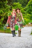 Two women carrying vegetables along a rural road