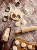 A baking arrangement with cut-out scones and utensils (seen from above)