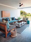 Seating area on roofed patio with table made from pallets and solid wooden stool