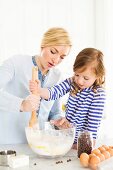 A mother and daughter stirring cake mixture