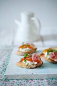 Crostini topped with cream cheese, apricots and ham