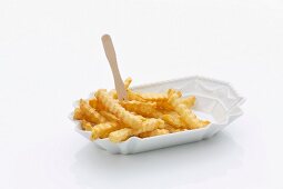 Crinkle cut chips with a wooden fork in a porcelain dish