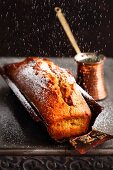 Arabian coffee cake being dusted with sugar