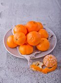 Mandarins on a plate, one peeled