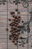 Allspice berries on a bamboo mat (seen from above)