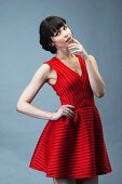 A dark-haired woman wearing a red mini dress