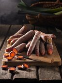 Purple carrots on a wooden chopping board