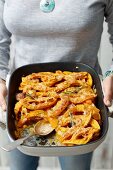 A woman with a pumpkin and sweet potato bake