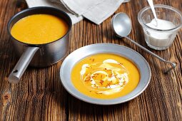 Cream of pumpkin soup garnished with cream and saffron