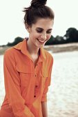 A laughing young woman wearing an orange overall