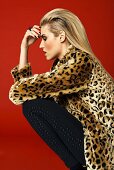 Blonde Frau mit Mantel im Leoparden-Look und schwarzer Hose