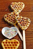 Sweet heart-shaped waffles on sticks with sugar pearls
