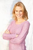 Blonde Frau in fliederfarbenem Pulli mit Lurex und Pailletten