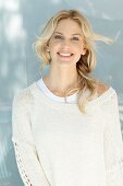 Junge blonde Frau in naturfarbenem Wollpullover