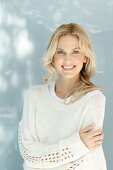 Junge blonde Frau in naturfarbenem Wollpullover