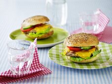 A cheeseburger with cucumber and tomatoes