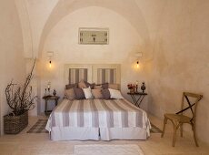 Double bed with striped bedspread in Apulian trullo