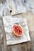 A halved blood orange on a newspaper