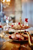 Macaroons, tartlets and raspberries on an elegant cake stand