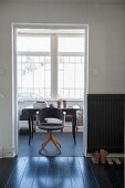 View of retro chair at black desk seen from hallway