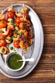 Prawns skewers with cherry tomatoes, bread and basil