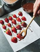 Erdbeeren mit Schokoladenstreifen überziehen