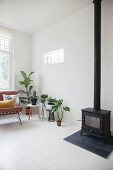 Skandinavisches Wohnzimmer mit Zimmerpflanzen und Kaminofen