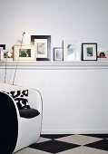 Various pictures stood on DIY shelf with white-painted moulded trim