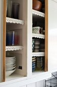 Old kitchen cabinet with lace trim on edges of shelves