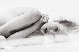 A young naked woman lying down (black-and-white shot)