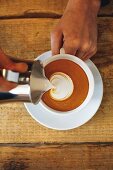Latte-Art-Weltmeister beim zubereiten eines Cappuccinos mit Milchmuster