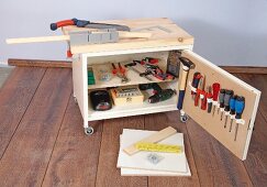 Small workbench on castors with wooden top and cupboard