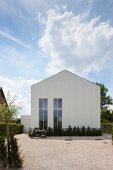 Modern house with gabled roof and tall windows stretching over two storeys