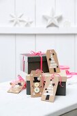 Festive gift tags hand-made from brown cardboard on gift boxes