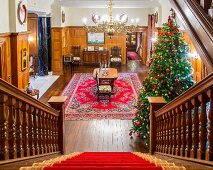 View of Christmas tree in grand hallway seen down staircase