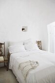 Old chairs used as bedside tables in Mediterranean bedroom