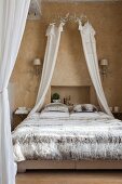 Double bed with unusual bed linen, crown and canopy in Mediterranean interior
