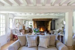 Rustic living room with wood-beamed ceiling and open fireplace