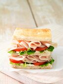 Wafer thin roast chicken with tomato and lettuce leaves