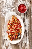 Fried carp with a honey and lemon sauce, almonds and pomegranate seeds for Christmas