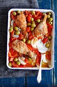 Oven-baked chicken drumsticks with peppers, onions and olives