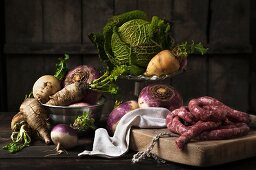 An autumnal arrangement featuring turnips, savoy cabbage and sausage